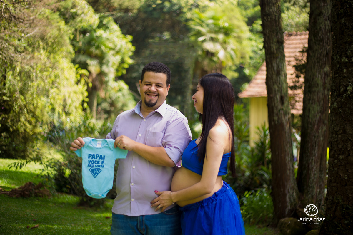 o pai segura a roupa enquanto a mae olha para ele no ensaio externo