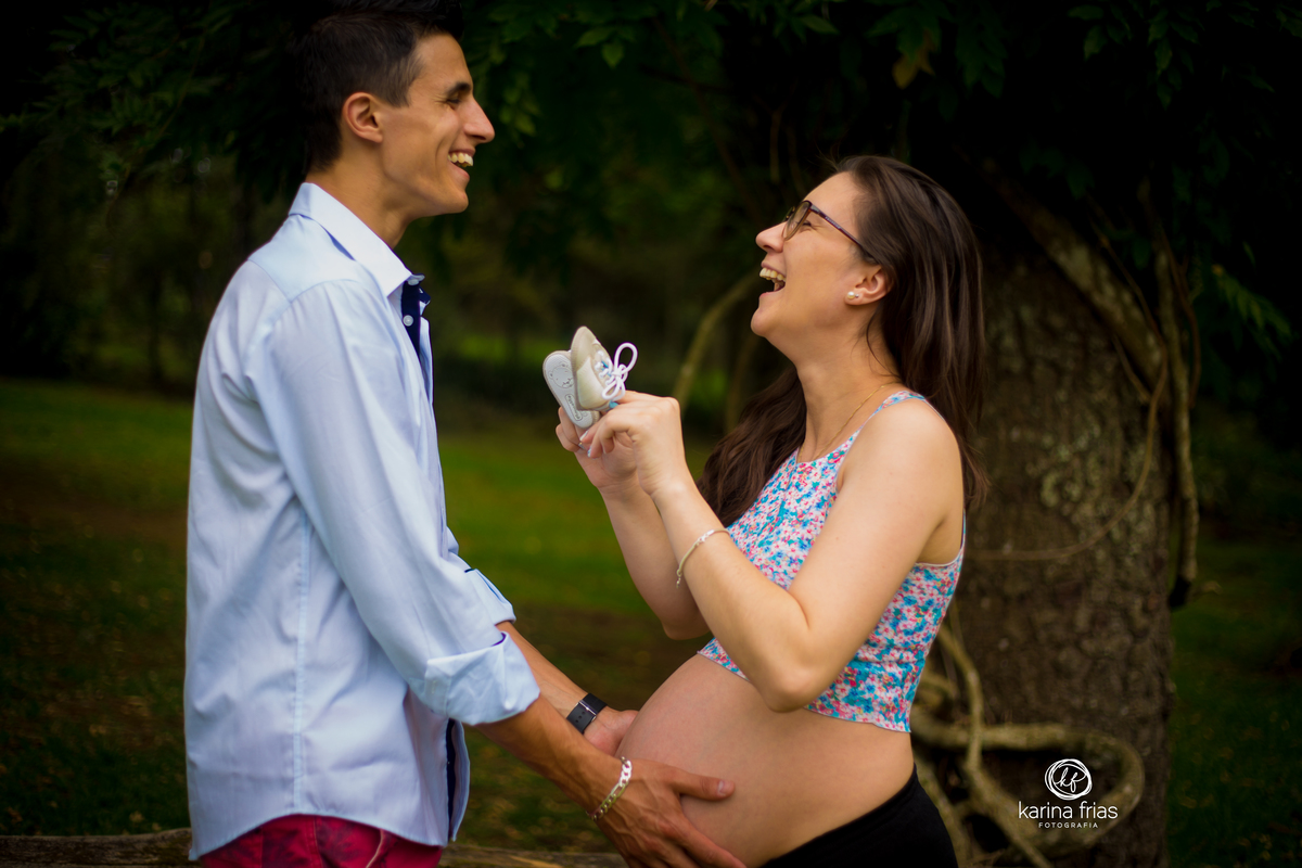 A MAE BRINCA COM O PAI FAZENDO CARINHO COM OS SAPATINHOS DO BEBE