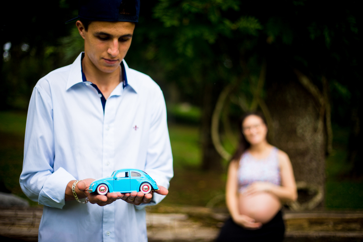 O PAI OLHA O FUSCA QUE É SUA PAIXAO ENQUANTO A MAE OBSERVA E A FOTOGRAFA REGISTRA