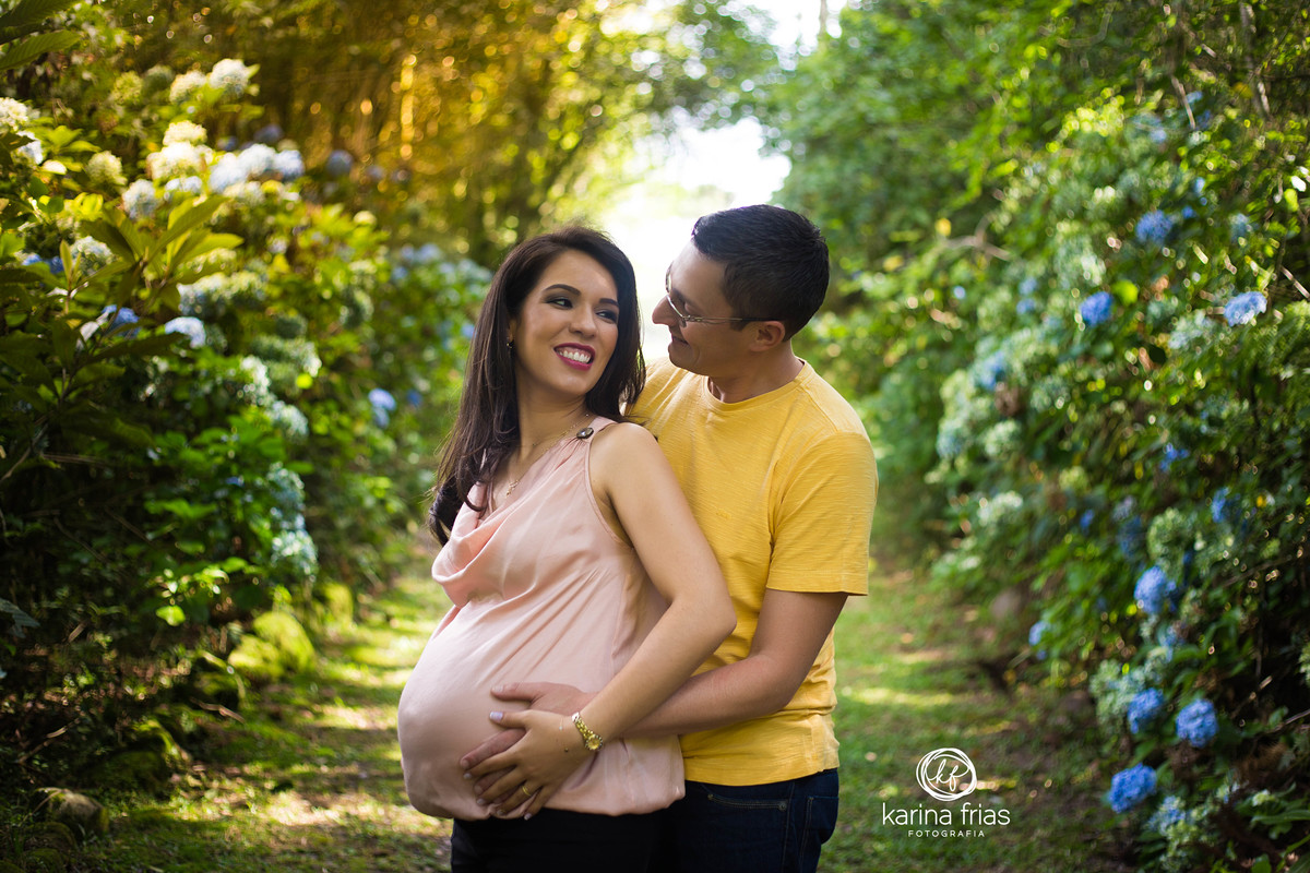 o pai fala algo para a gestante enquanto ela sorri para as fotos 