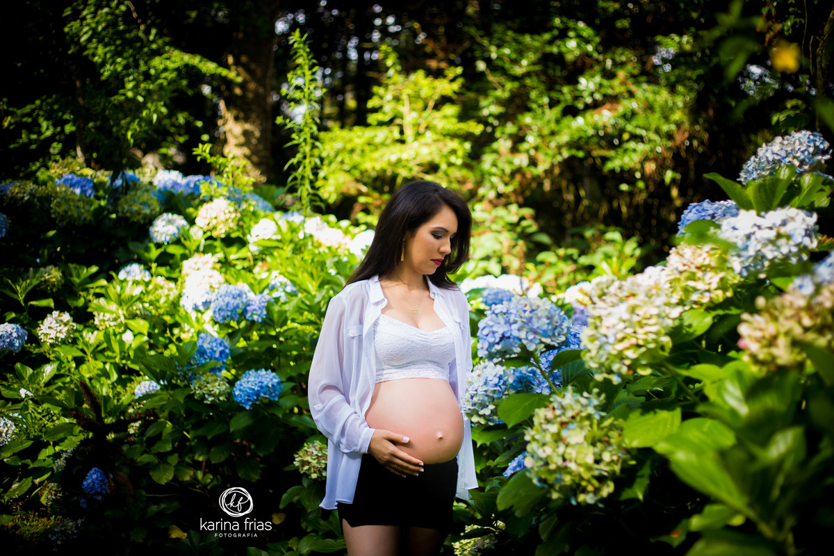 a gestante olha as flores na sua sessão externa 