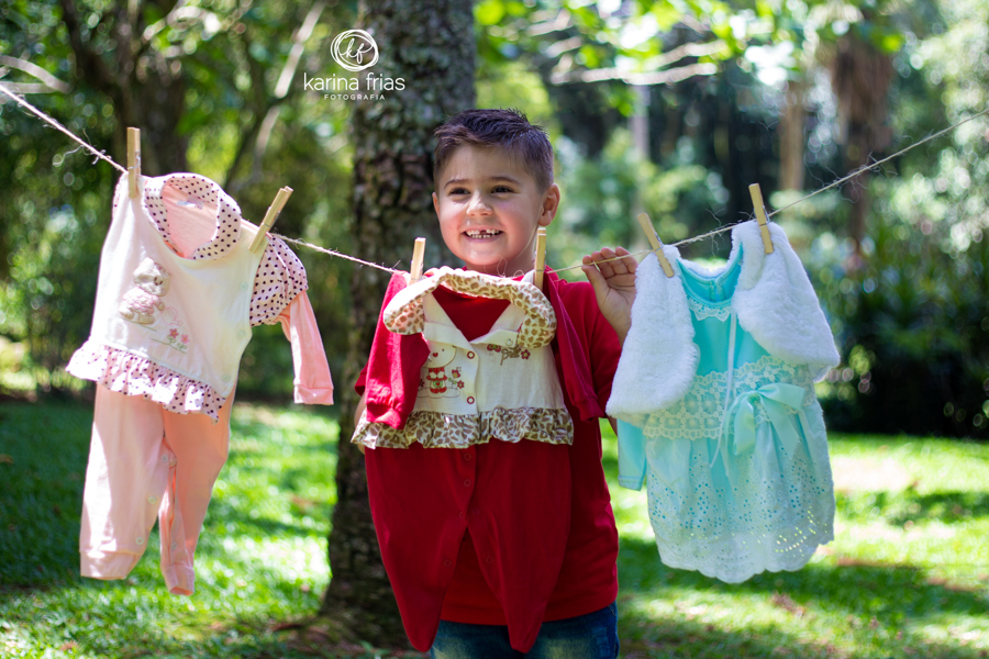 O MENINO ESTA SEGURANDO O VARAL PARA AS FOTOS DE GESTANTE DA MÃE