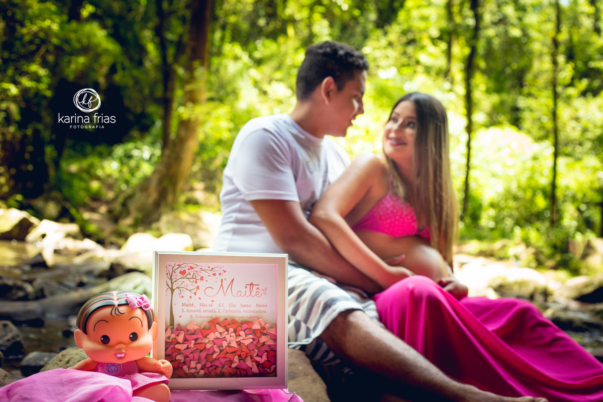 os pais se olham enquanto a fotografa de familia arruma os acessorios para a foto