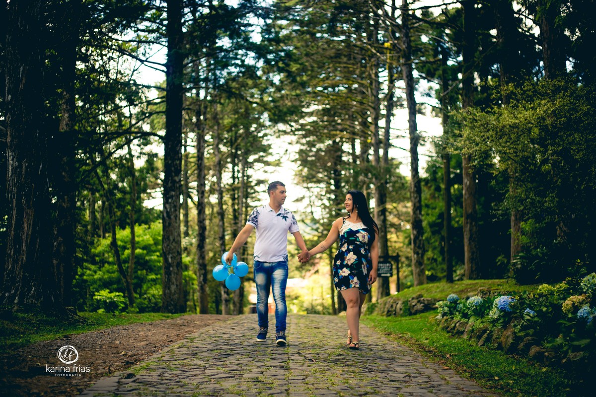 OS PAIS CAMINHAM SEGURANDO O BALÃO PARA AS FOTOS DE GESTANTE