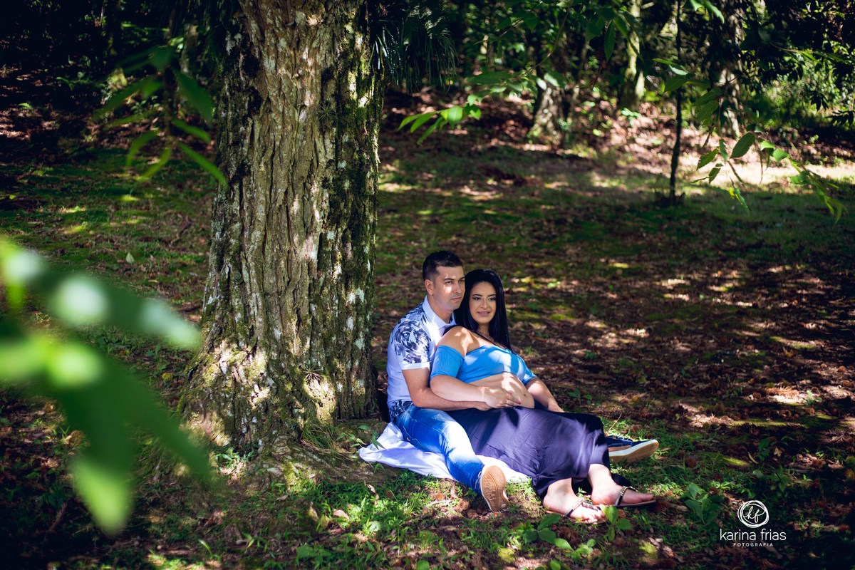 OS PAIS ESTAO SENTADOS EMBAIXO DA ARVORE NO ENSAIO GESTANTE