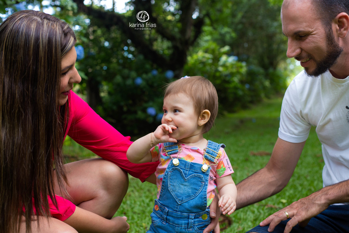 A CRIANÇA SORRI PARA OS PAIS NA SESSÃO FOTOGRAFICA DE FAMILIA