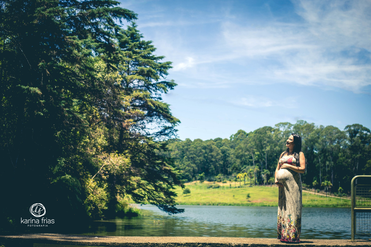 a gestante posa perto do lago para as fotos do seu book