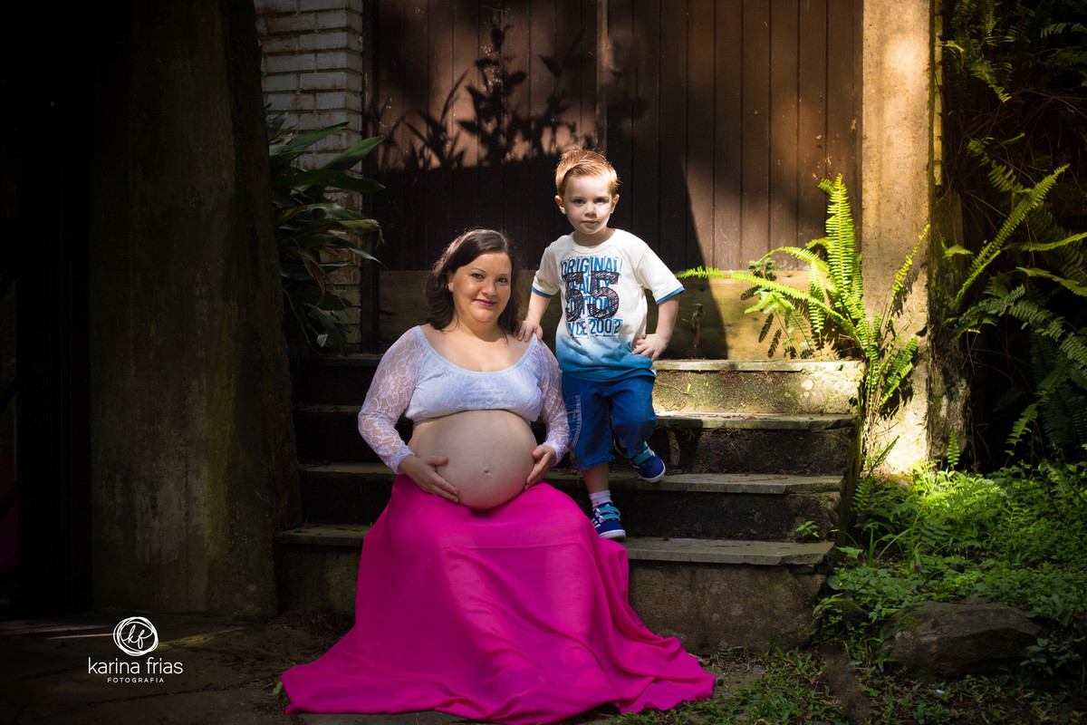 O FILHO FAZ POSE COM A MAE PARA AS FOTOS DE GESTANTE