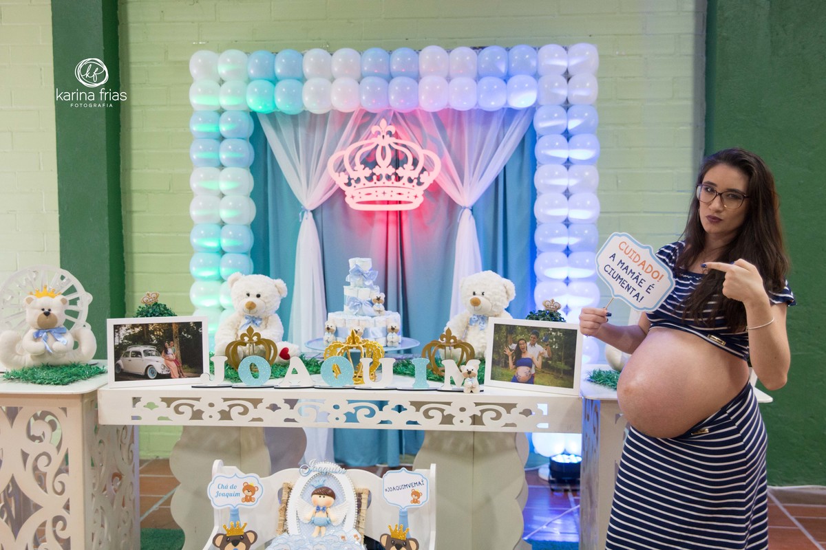 A GESTANTE SEGURA UMA PLAQUINHA EM SEU CHA