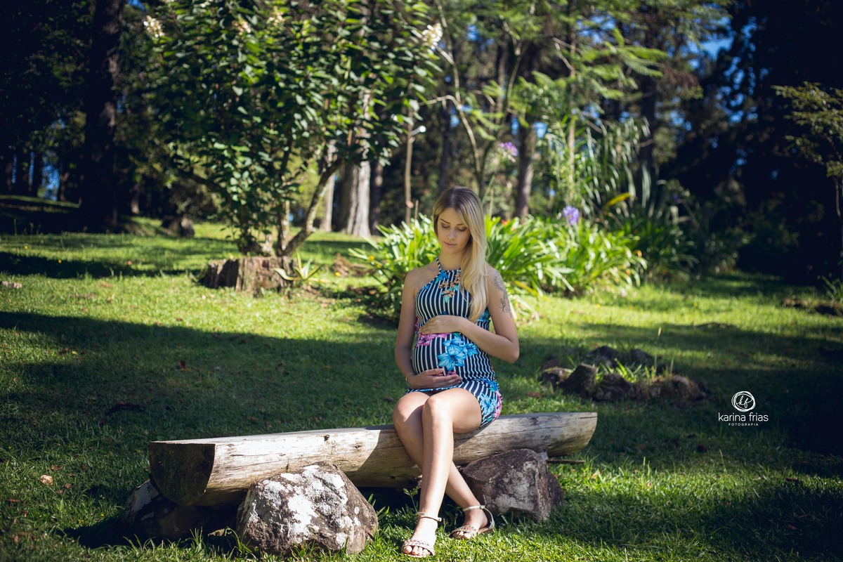 a gestante olha para a barriga durante a sessão de fotos