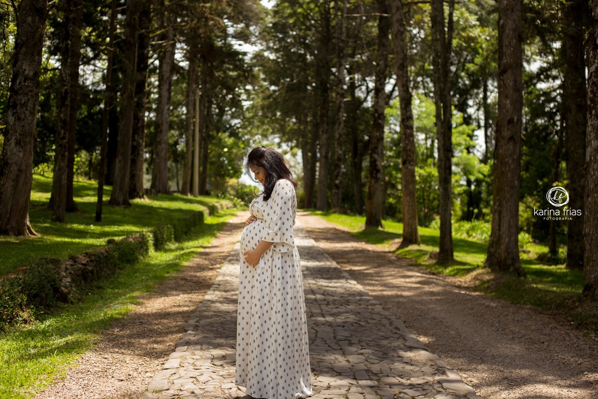 a gestante segura a barriga na sessão de fotos