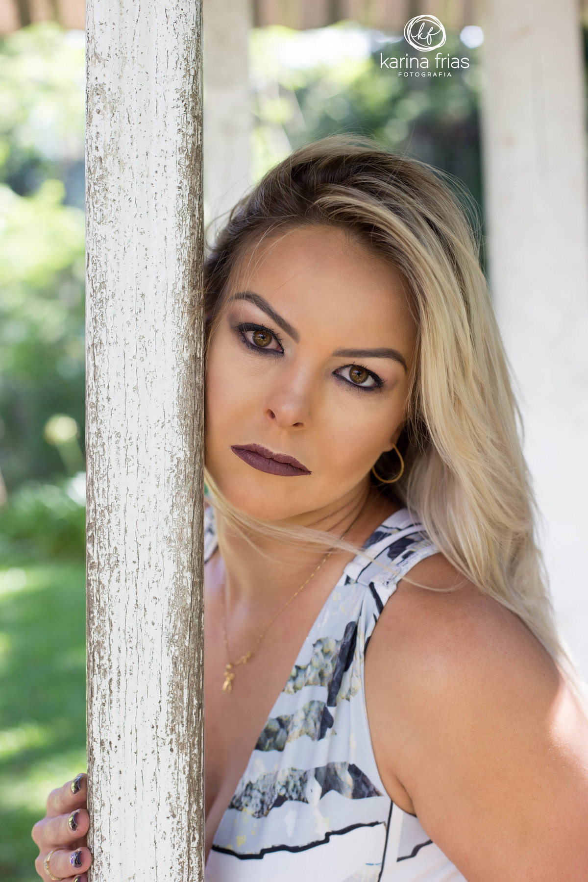 GABRIELA SE ENCOSTA NA MADEIRA E OLHA PARA A FOTOGRAFA NO ENSAIO EXTERNO