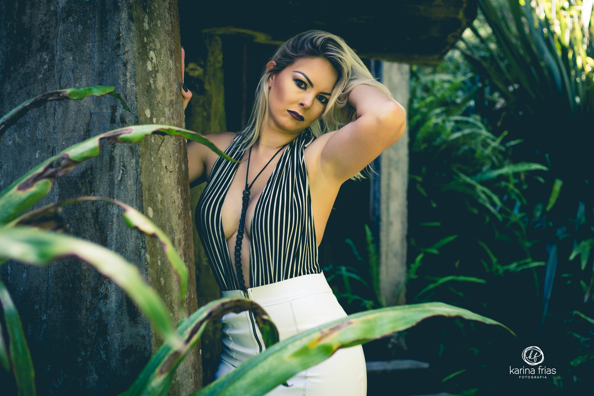 A MODELO LEVANTA O BRAÇO E OLHA PARA A CAMERA