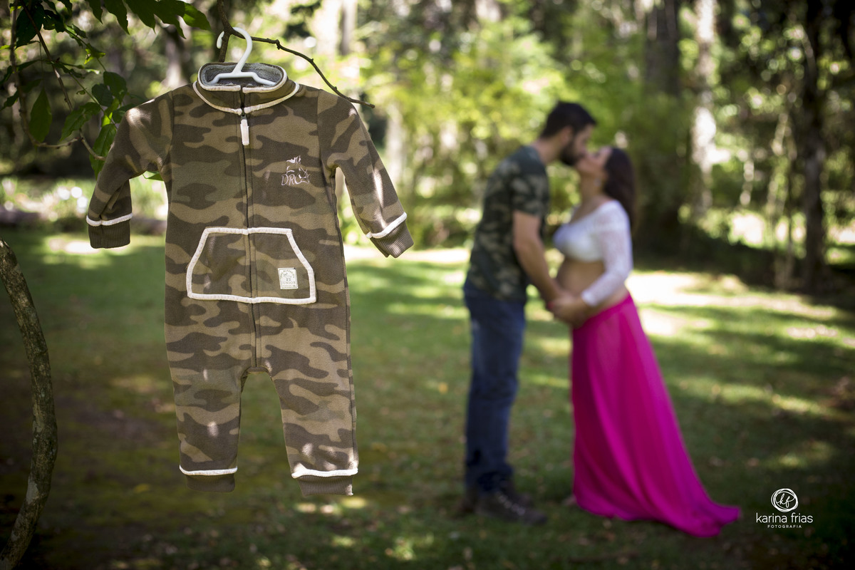 A ROUPINHA DO BEBE É UTILIZADA COMO ACESSÓRIO E OS PAIS SE BEIJAM AO FUNDO