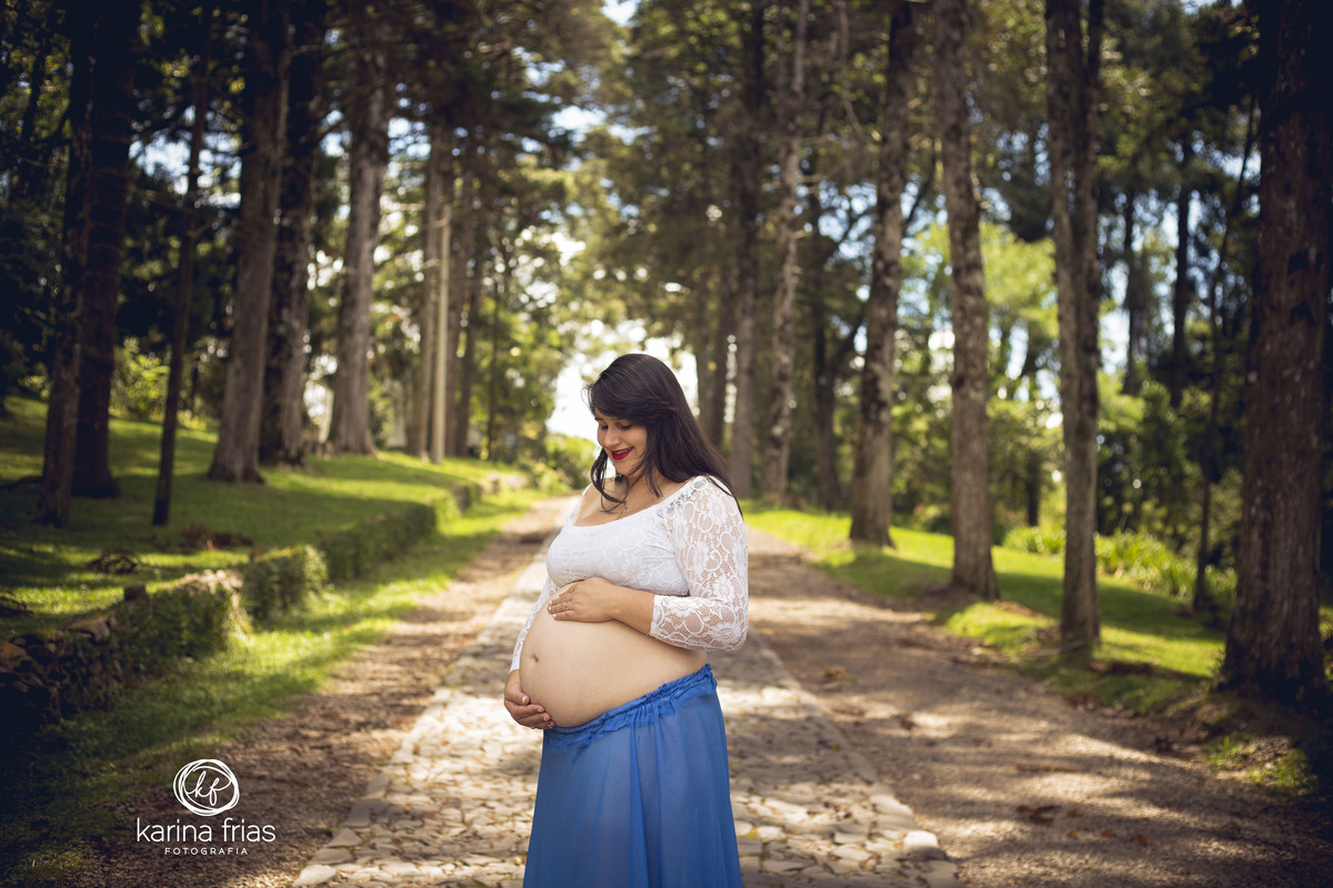 A GESTANTE OLHA A BARRIGA DURANTE A SESSÃO EXTERNA