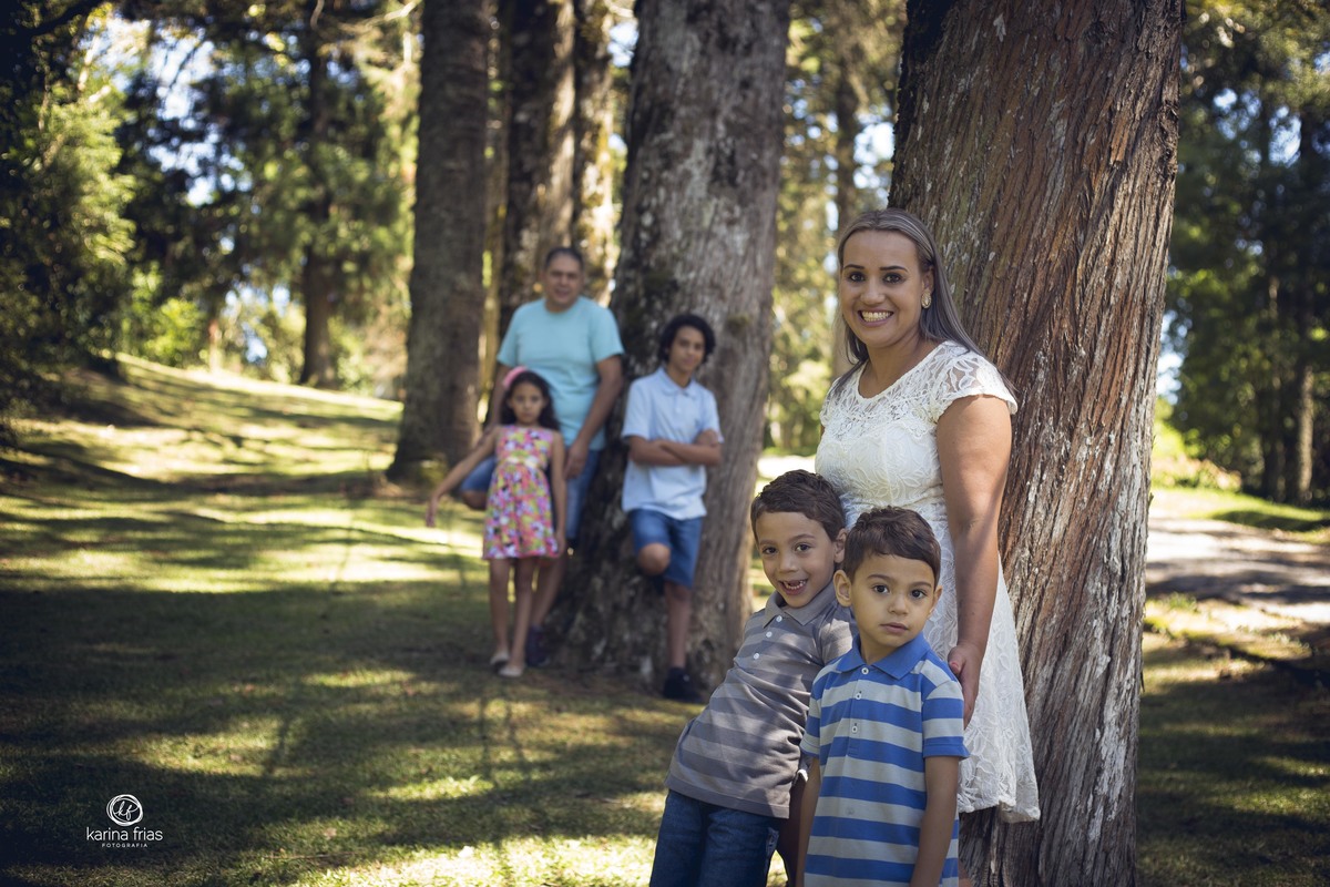 a mãe e os gemeos estao focados na frente enquanto o pais e os outros dois filhos estão ao fundo desfocados