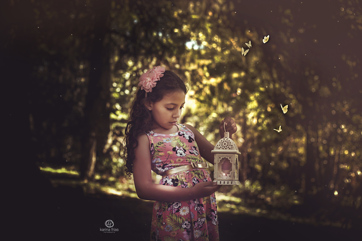 a menina olha a luz que sai do malpiao no ensaio de familia