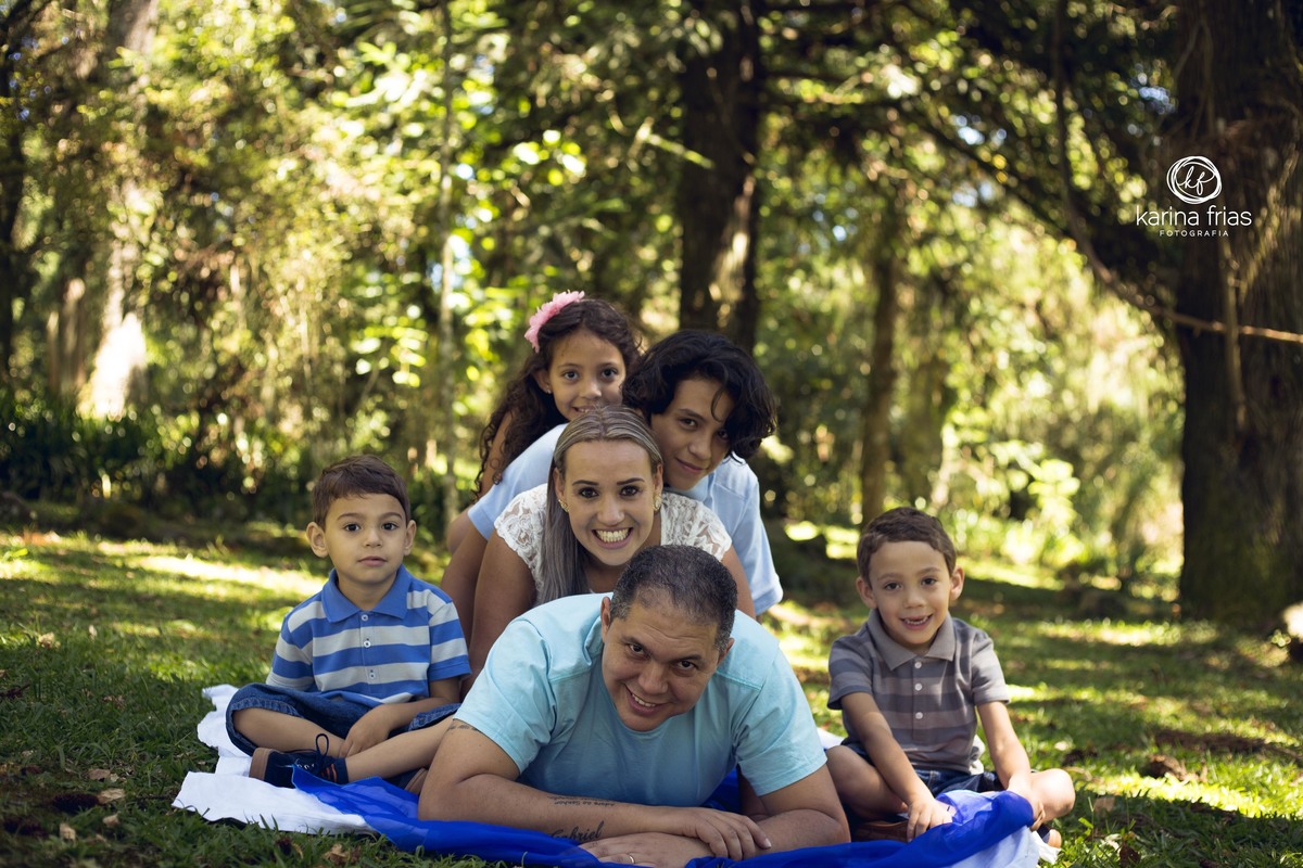 a familia faz uma filha em cima do pai para a sessão de fotos
