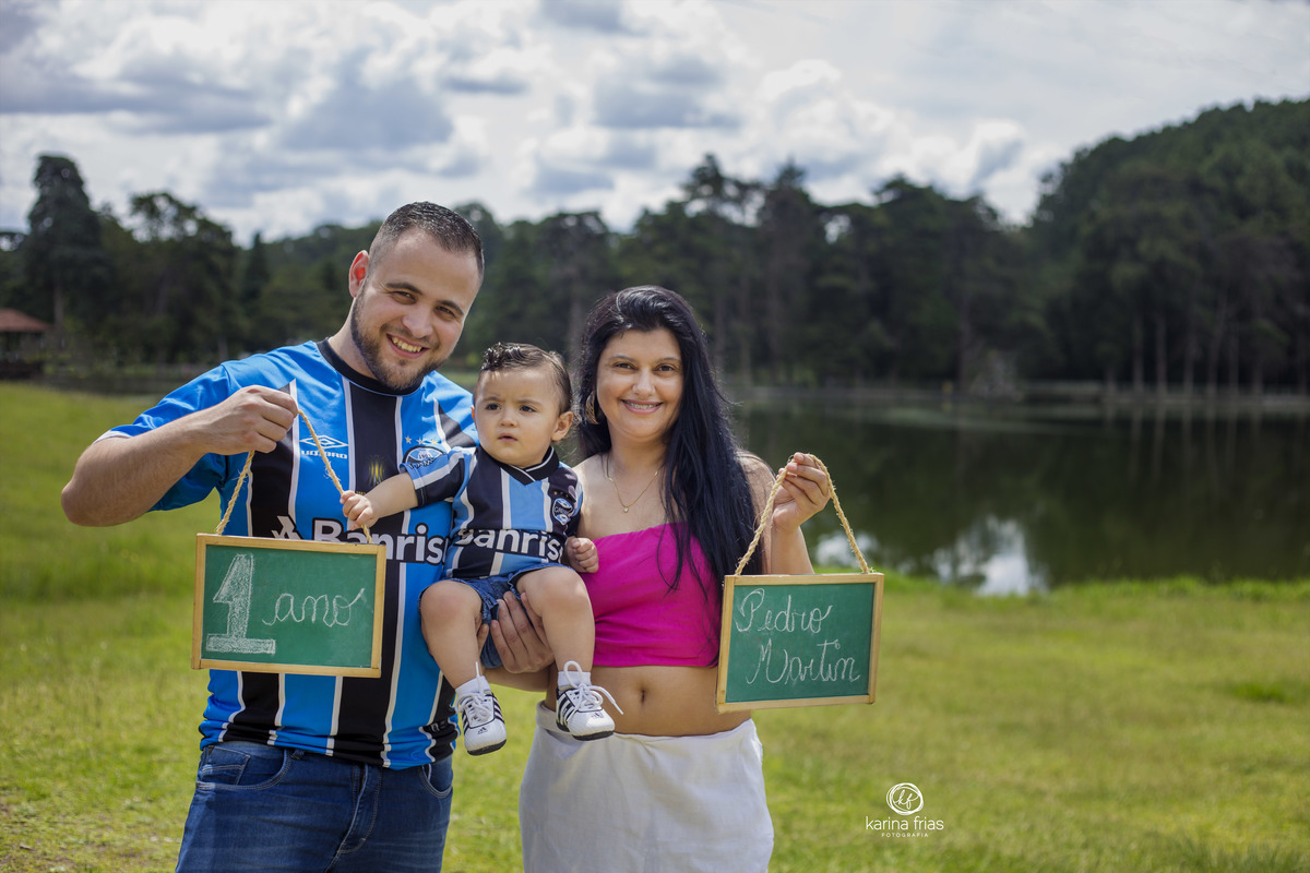 A FAMILIA SEGURA A CRIANÇA E AS PLAQUINHAS QUE SAO ACESSORIOS DURANTE ENSAIO