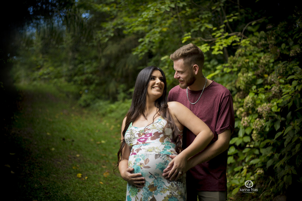 no ensaio de gestante os pais se olham e sorriem