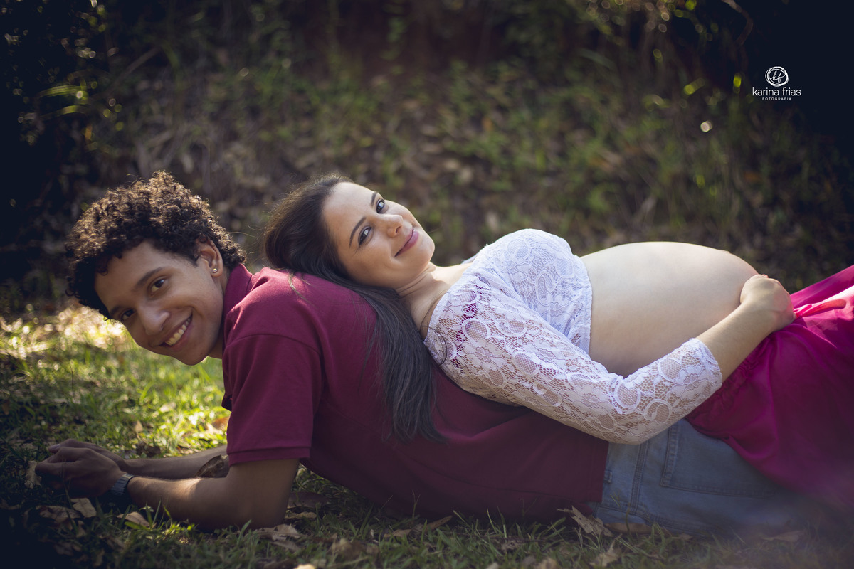 a mae deita em cima do pai para as fotos de gestante