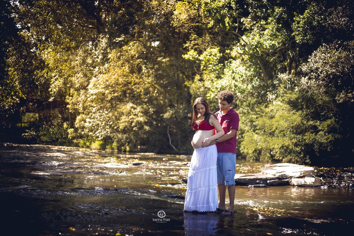 o casal esta no meio da agua no ensaio de gestante externo