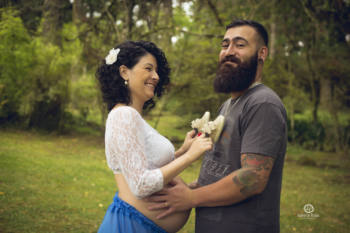 a gestante brinca com o esposo enquanto a fotografa de familia de caxias do sul registra o momento