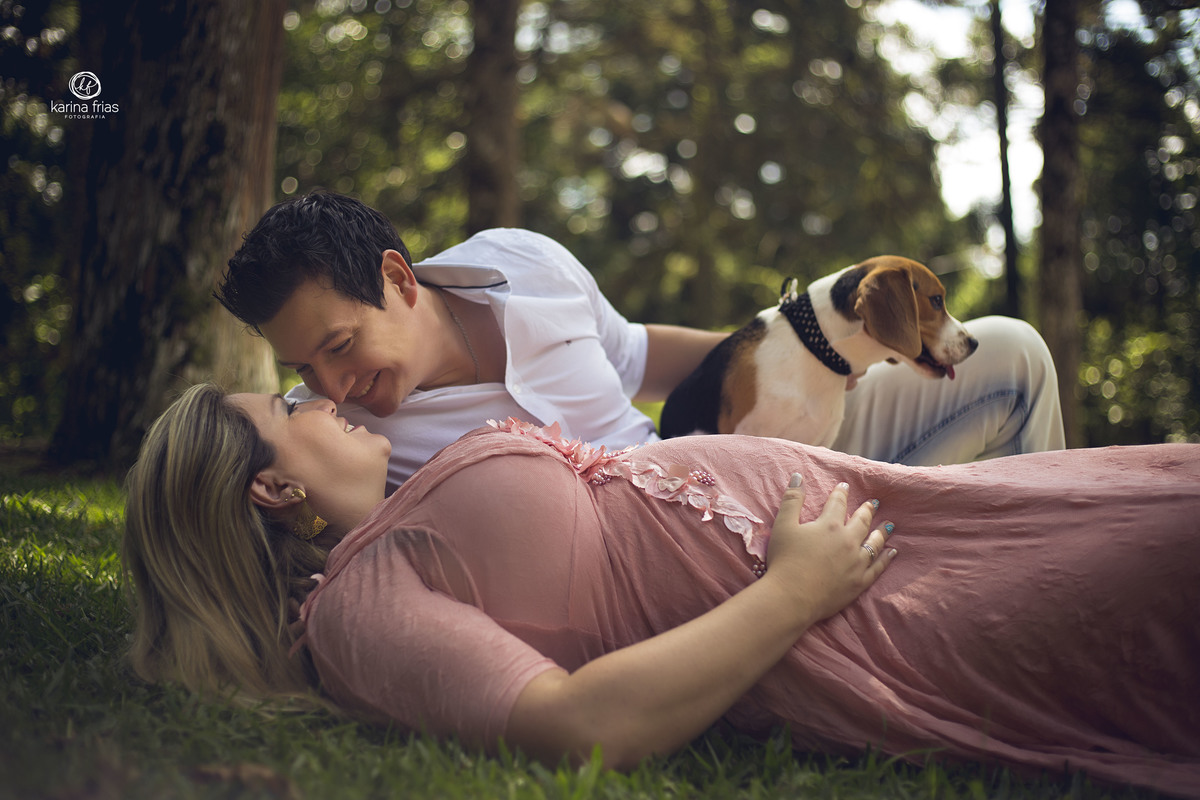o pai acaricia a mae na sessão de fotos externas de gestante