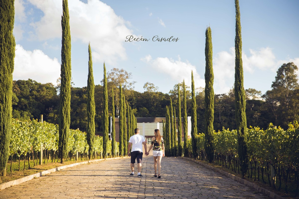 o casal caminha junto de maos dadas em vinicola de bento gonçalves