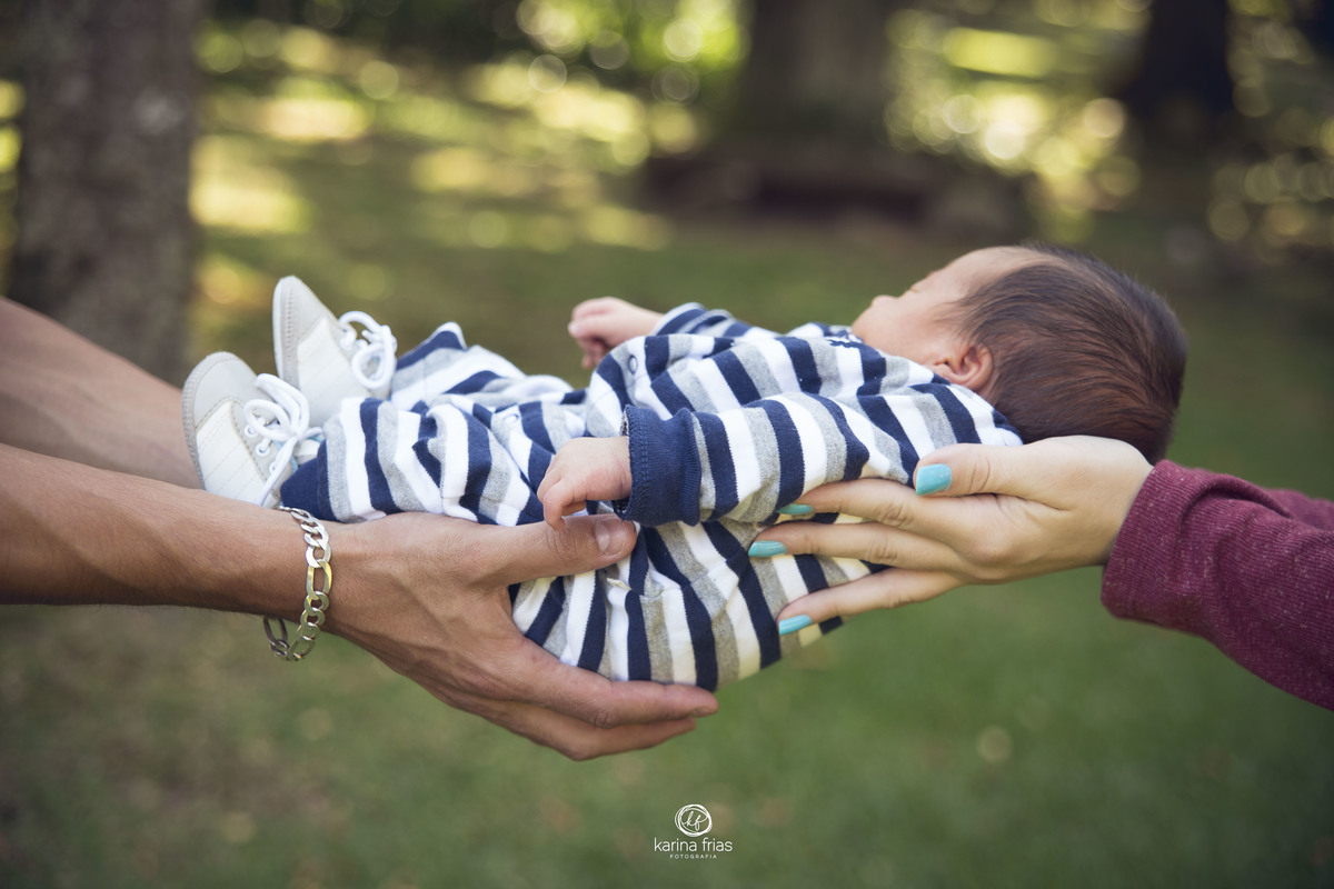 os pais seguram o bebe para o ensaio externo