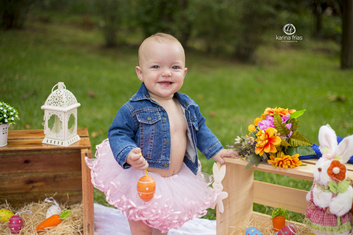 a bebe sorri para camera enquanto a fotografa de crianças registyra o momento