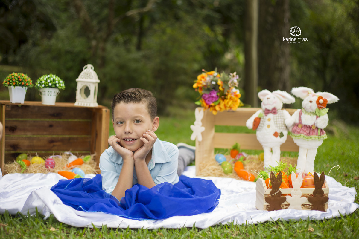 o menino esta deitado no cenario de pascoa