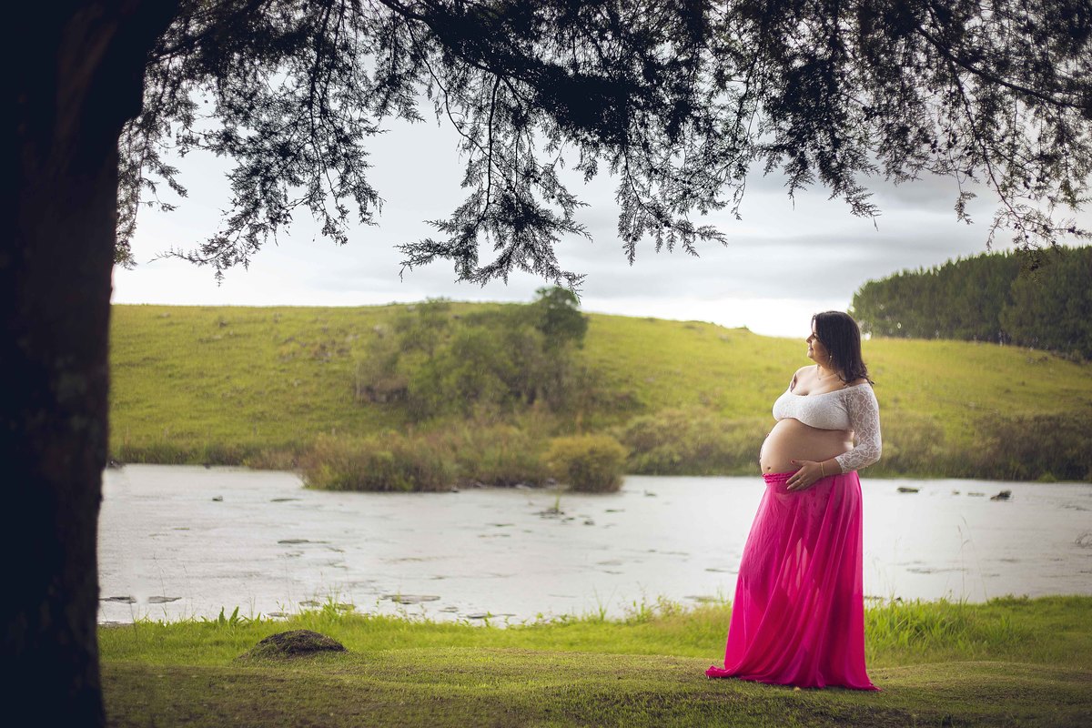 a gestante contempla o rio no ensaio