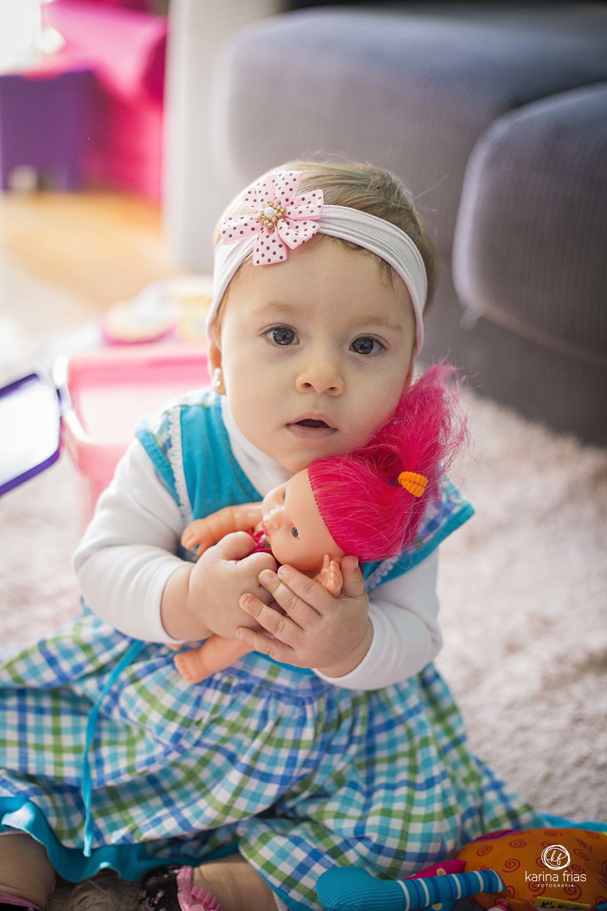 a menina abraça a boneca no ensaio infantil