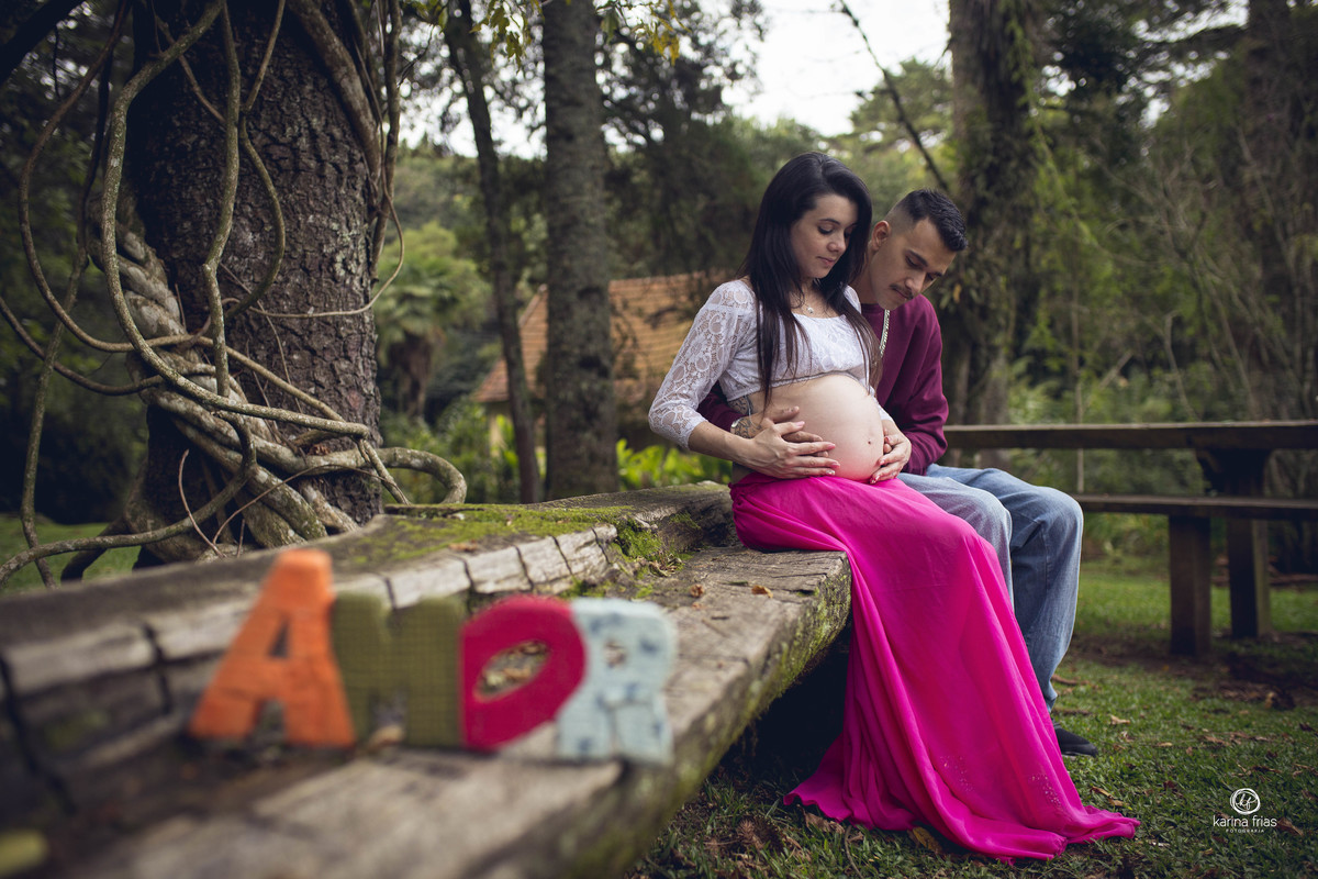os pais posam ao fundo do letreiro amor