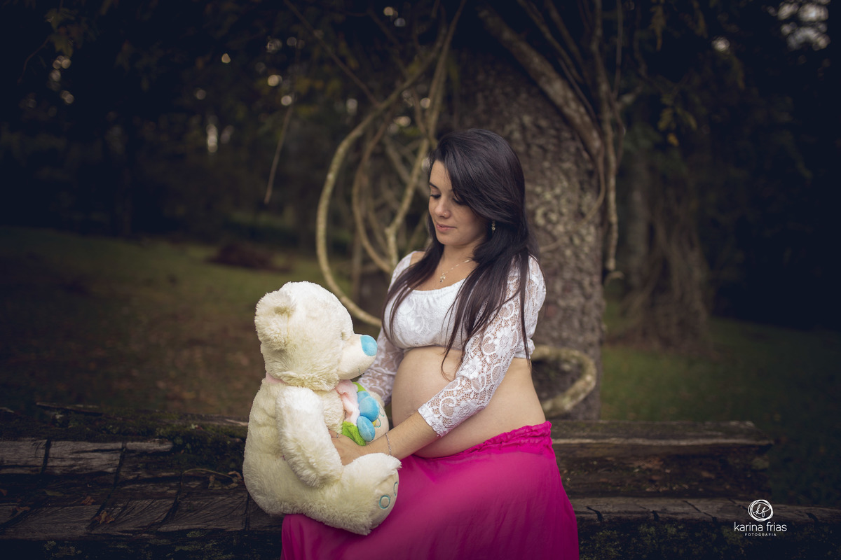 a gestante olha para o ursinho da filha