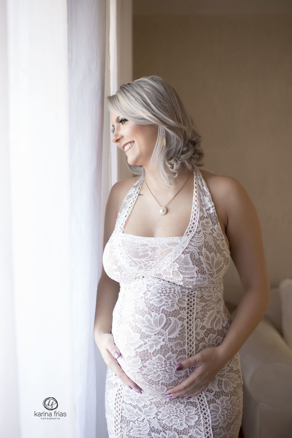 a gestante olha para a janela no ensaio