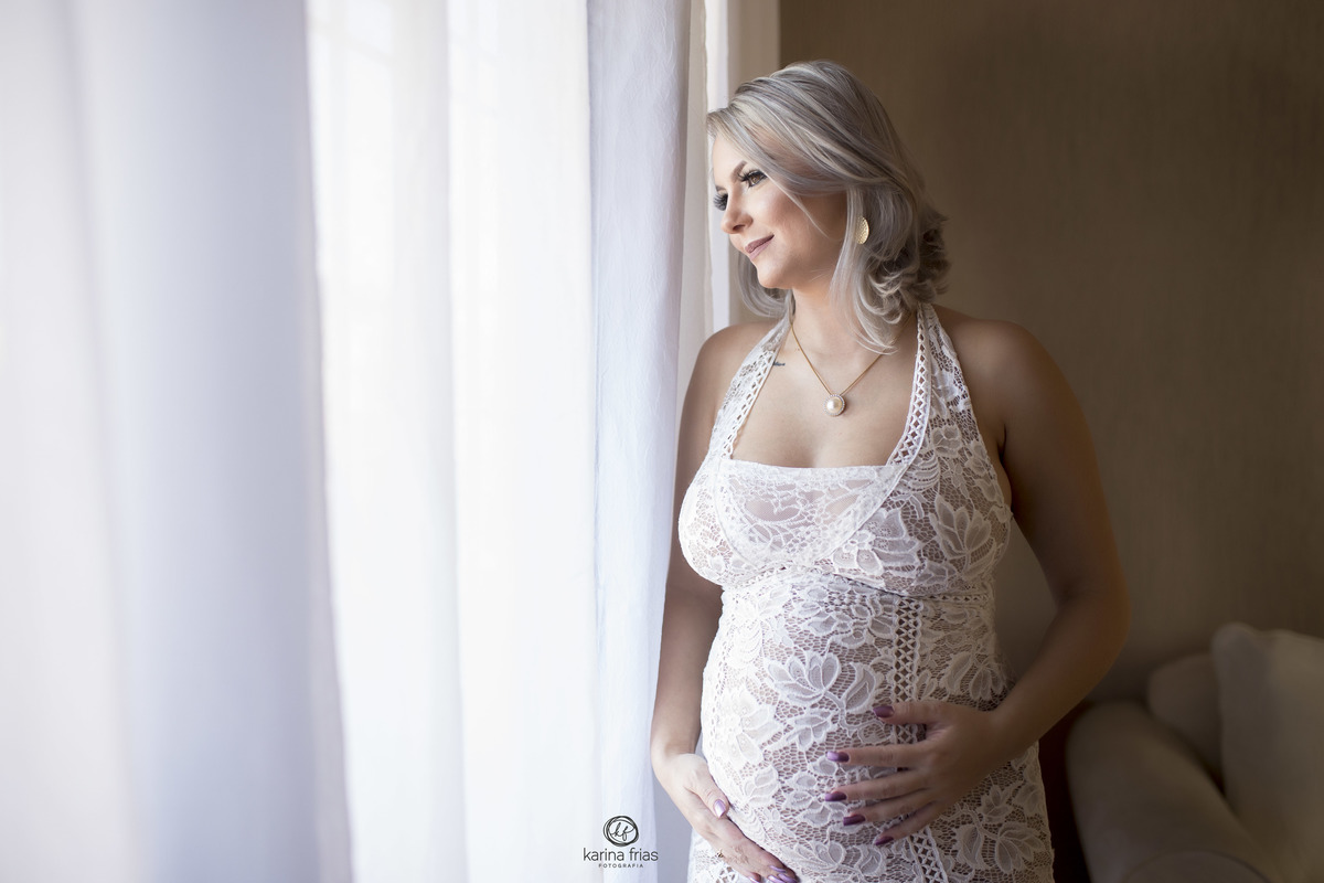 no ensaio de gestante a modelo esta frente a janela