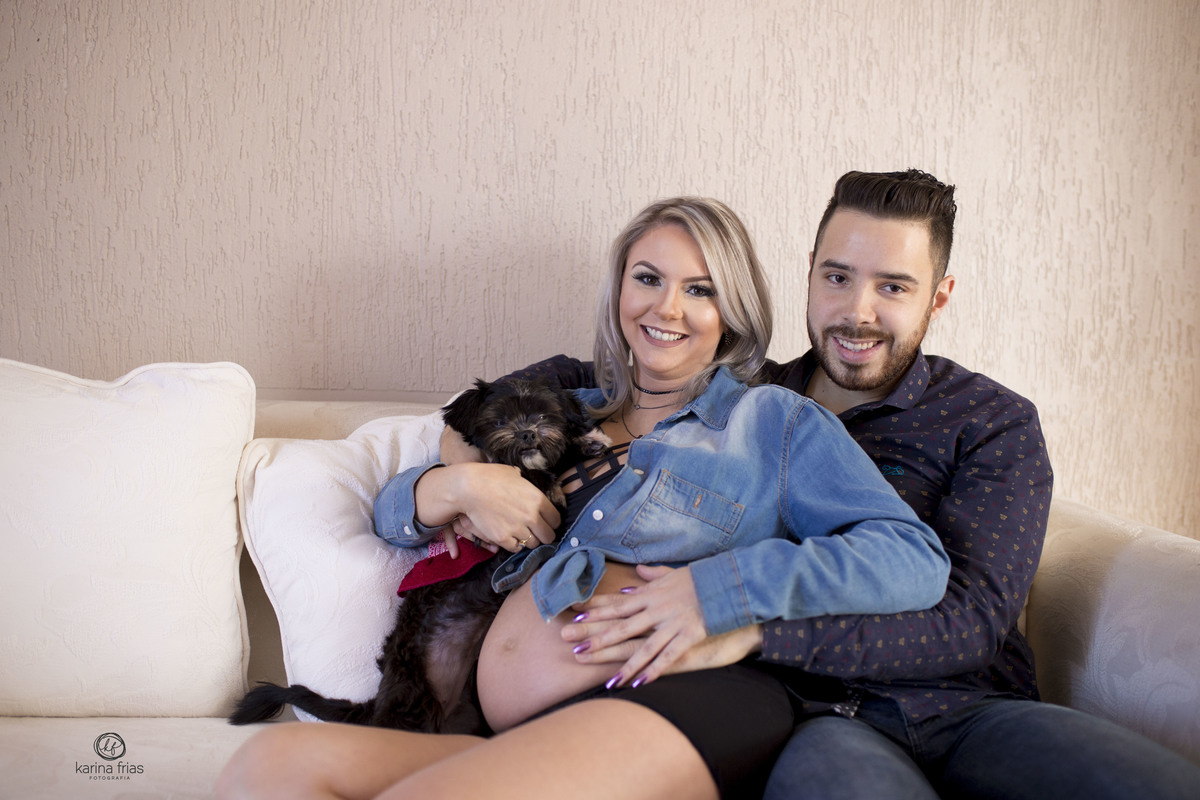 os pais abraçam a cachorrinha no ensaio de gestante