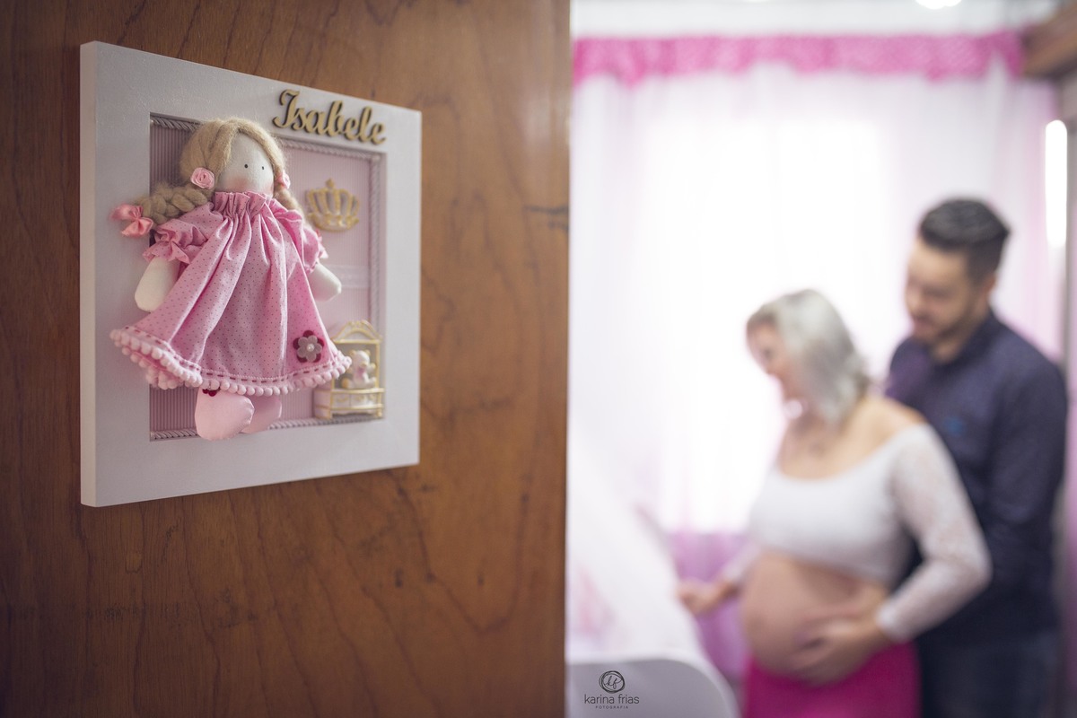 no ensaio de gestante, os pais ficam ao fundo no quarto da bebe