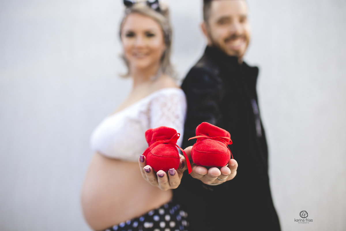 os pauis seguram os sapatinhos no ensaio gestante pinup