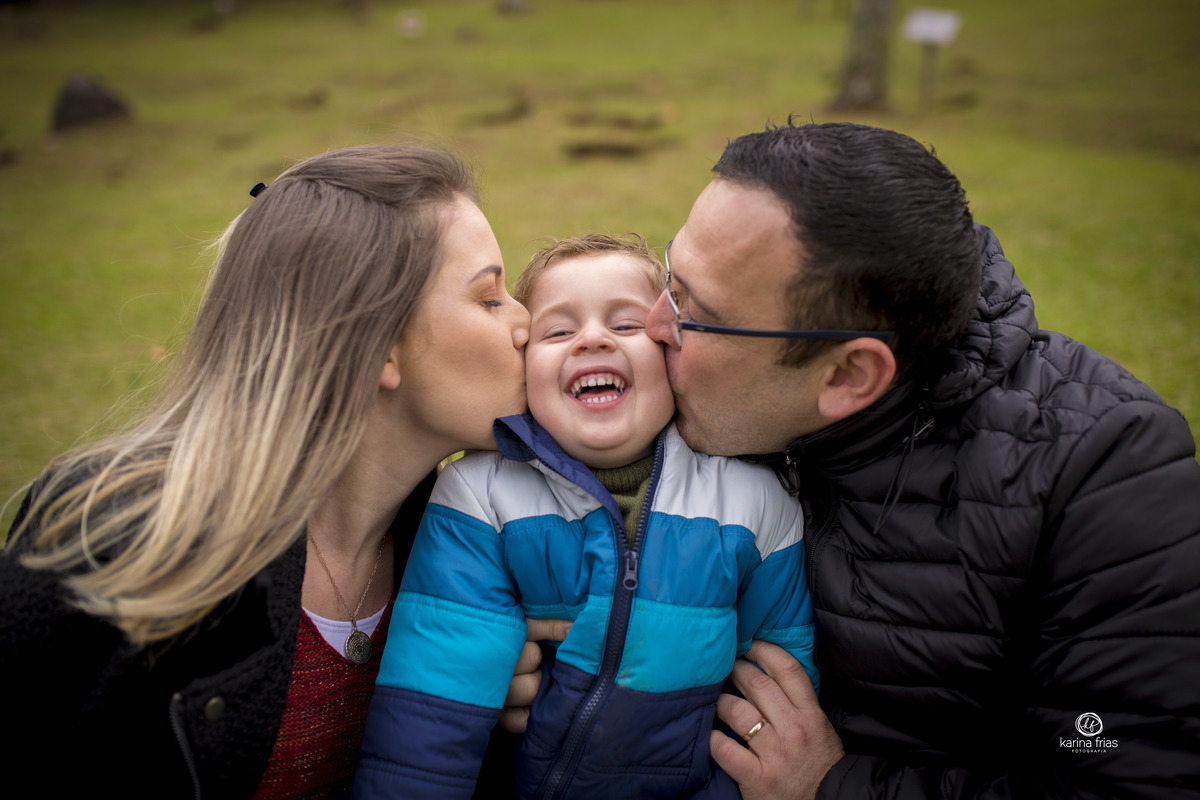 os pais beijam o filho no ensaio de familia externo