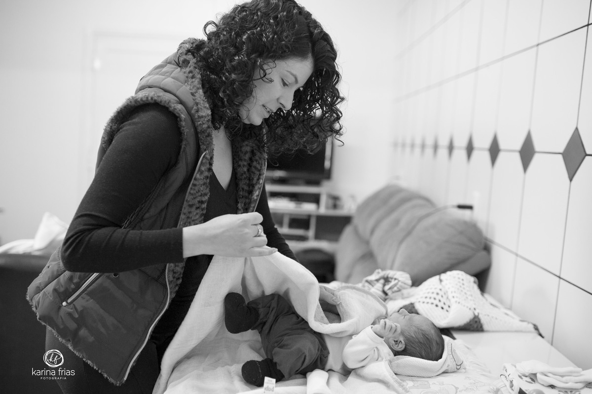 a mãe troca o bebe em sua casa