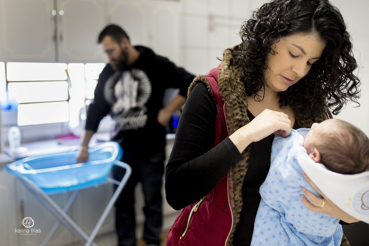 o pai prepara a agua para o banho do bebe
