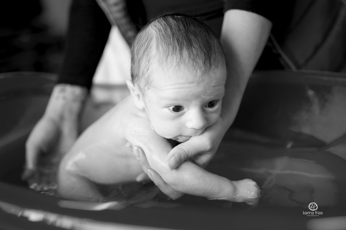 a mãe lava o bebe na banheira