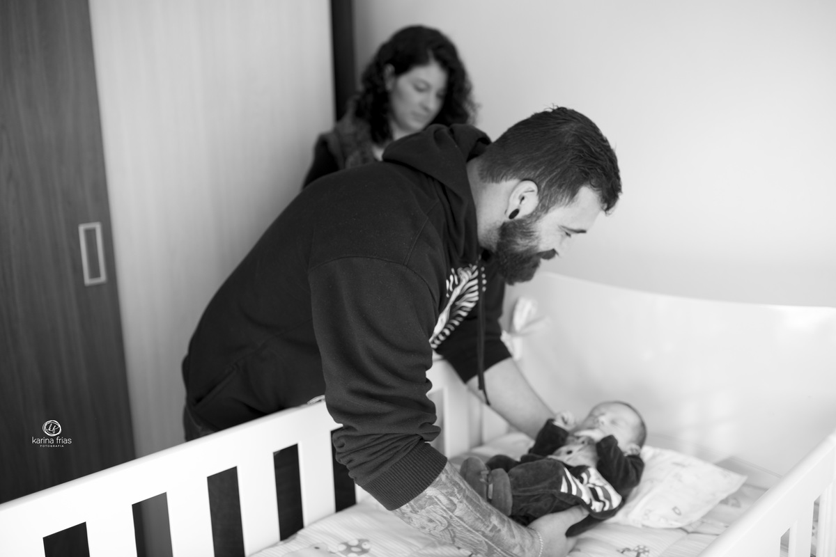 o pai esta colocando a criança no berço