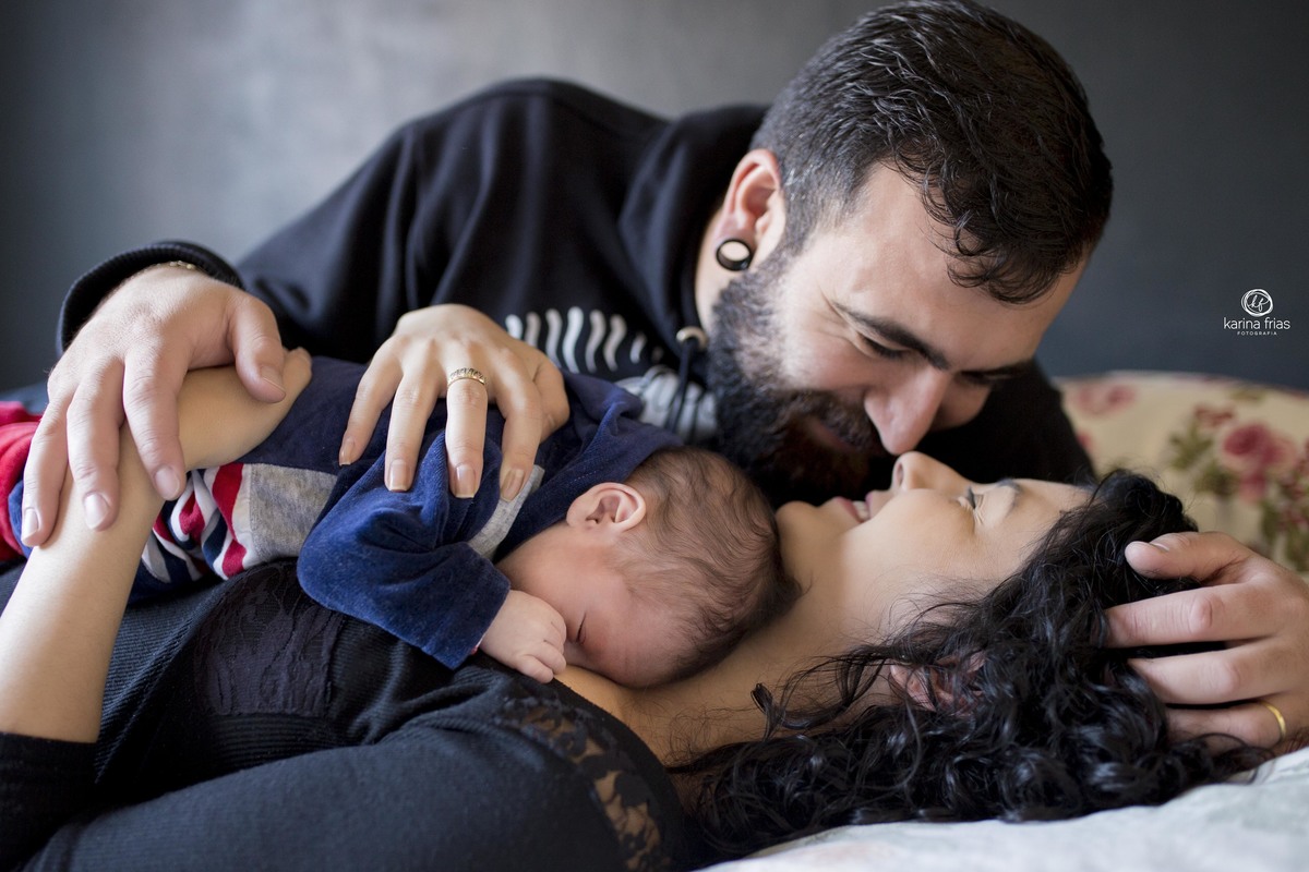 o pai acaricia a mae e o bebe dorme