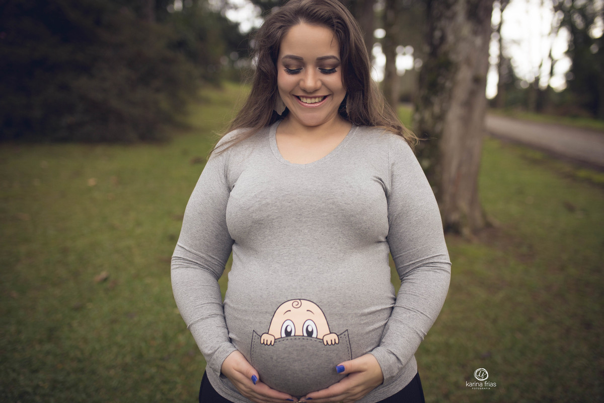 a gestante olha para a barriga durante o ensaio