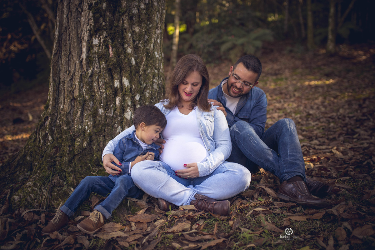 a familia olha para a barriga durante ensaio de gestante