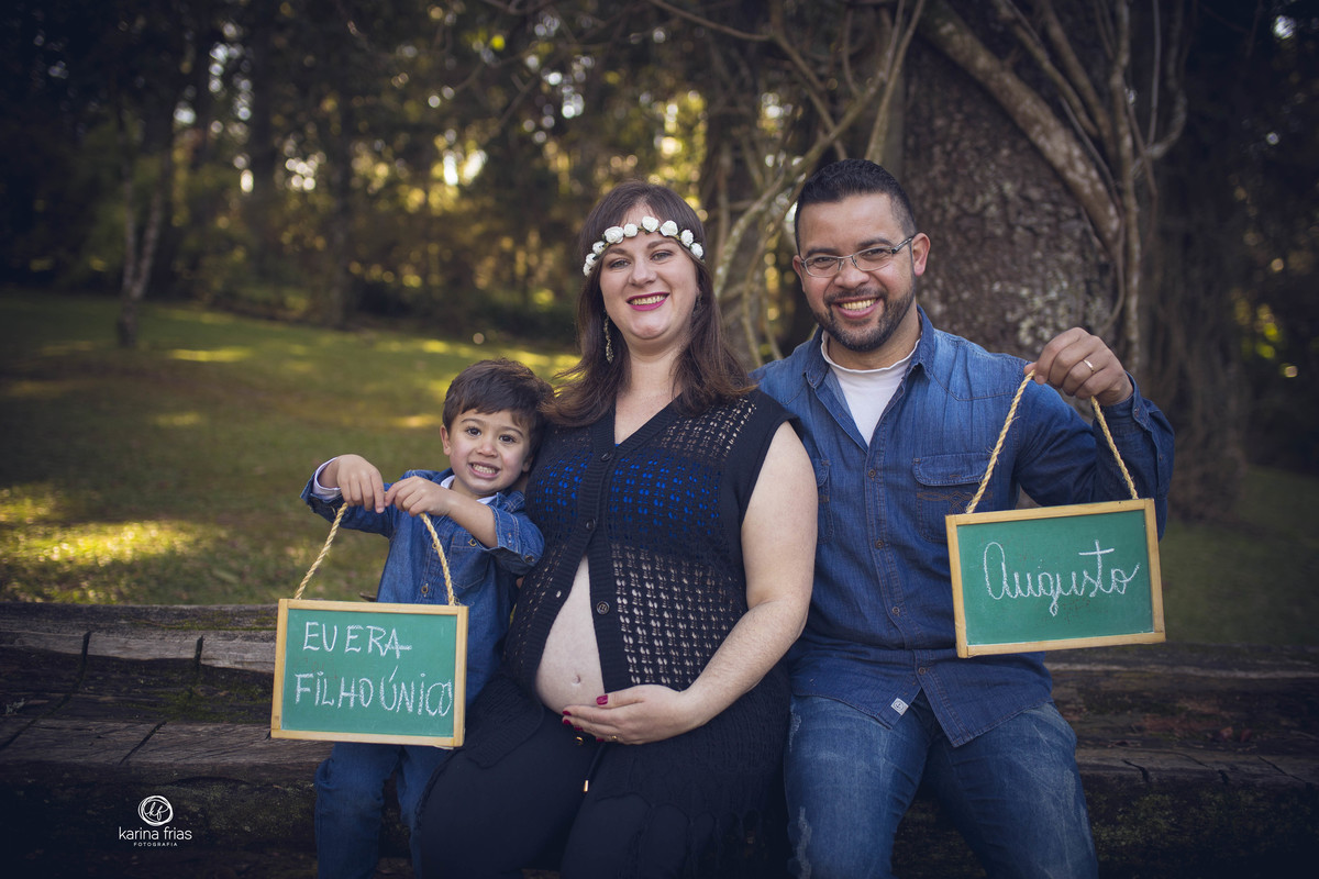 os meninos seguram as plaquinhas no ensaio de gestante
